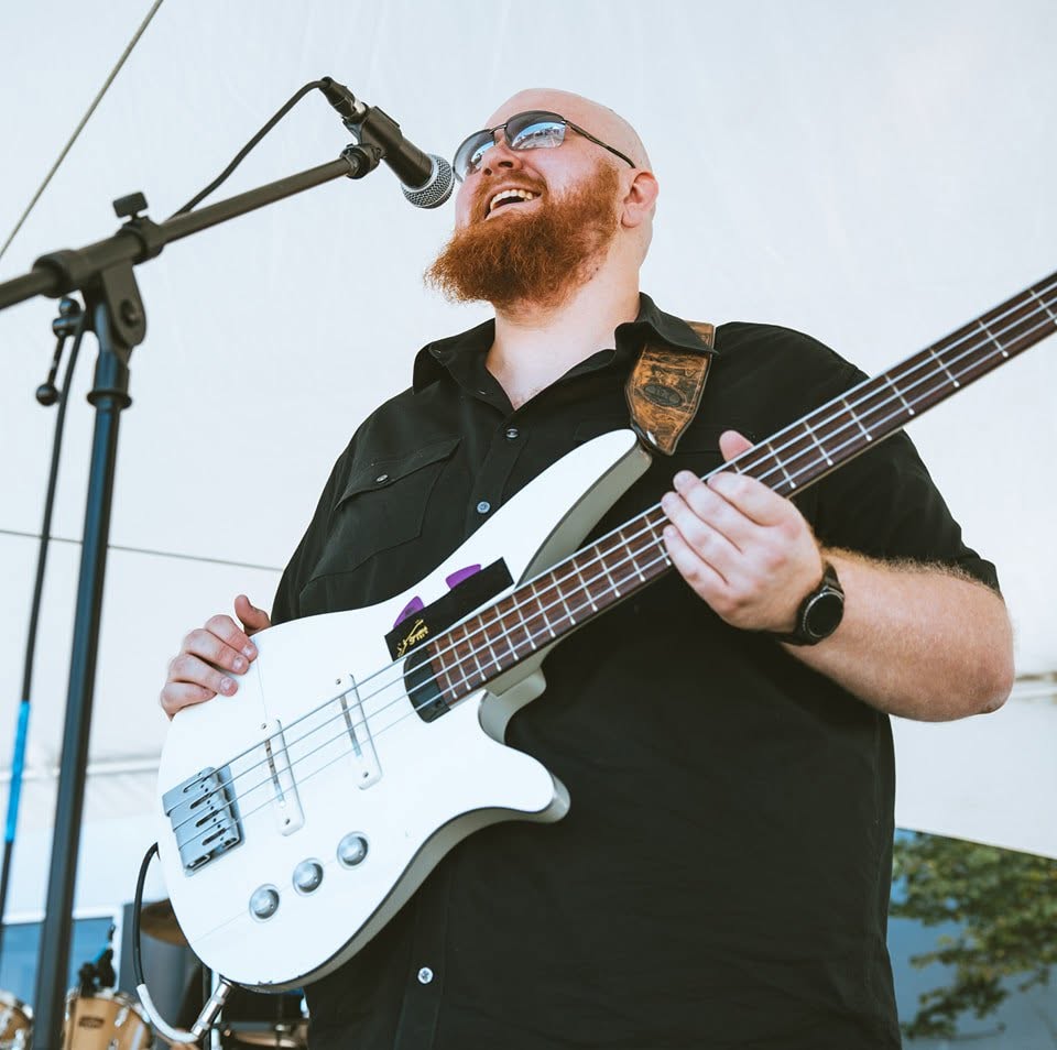 Photo of Artem Bank performing with a bass in hand.